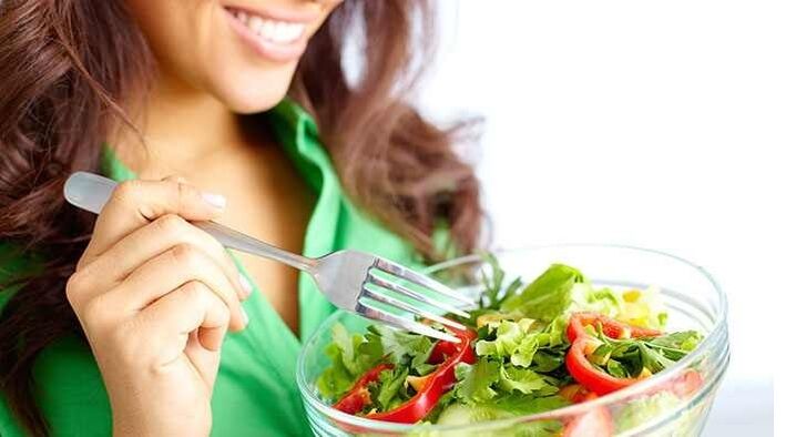 Chica comiendo ensalada de verduras en una dieta de proteínas
