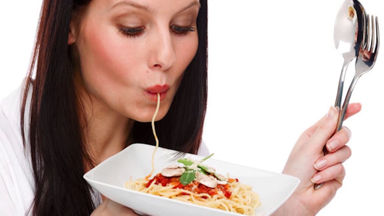 Mujer comiendo espaguetis con vientre delgado